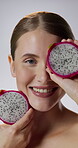Studio, face and woman with dragon fruit, skincare and confident with natural cosmetics for wellness. White background, portrait and happy person with pitaya for healthy skin, glow and dermatology