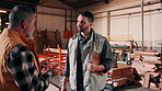 Team, men and talking in carpentry warehouse for production progress, project update or feedback. Carpenter, clipboard and people in discussion for manufacturing, quality control or material planning