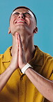 Hope, prayer and religion with man pleading in studio for begging, confession or wish. Asking, luck and praying with desperate person on blue background for belief, christianity or faith in God