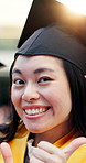 Happy, face and Asian woman at graduation with thumbs up, college success and achievement. Portrait, graduate and person with emoji, wink and smile for education, university goal or celebrate outdoor