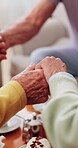 Friends, house and people holding hands in elderly club for support, solidarity or grace at tea party. Retirement home, community and connection with senior circle, group or love and prayer for meal