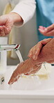 Help, washing hands and senior person with caregiver in bathroom for grooming, clean and hygiene. Elderly patient, nurse and support for self care, running water or wellness in assisted living home