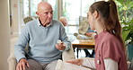 Talking, caregiver and senior man with medication, pills and explain dose for healing, healthcare and help. Nursing home, nurse and elderly patient listening for instructions, advice and prescription