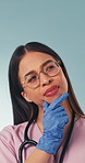 Thinking, woman and nurse in studio with planning, unsure or problem solving for medical diagnosis. Glasses, gloves and healthcare worker on blue background with solution, doubt or choice on service.