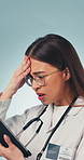 Doctor, woman and stress in studio with tablet, medical research and bad news for patient diagnosis. Healthcare worker, person and concern with tech, online test results and error on blue background.