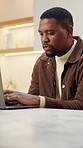 Laptop, typing and black man in kitchen for remote work, timesheet or report for HR administration. Human resources, African person and review with employee hours, payroll and planning in home