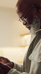 Tablet, reading and senior black man in home for internet, news or blog post with online information. Tech, search and person with app to check article, newsletter and browsing website in retirement