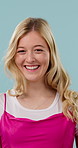 Face, woman and wind in studio with hair care, confidence or happy for salon keratin treatment results. Female person, smile and hairstyle with breeze, cosmetology or satisfaction on blue background.