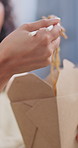 Chinese food, eating and hands with woman in home for takeaway, nutrition and lunch. Chopsticks, takeout and hungry with person and order in living room in house for meal, asian cuisine and relax