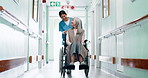 Walking, nurse and old woman in wheelchair at hospital for appointment, checkup and medical care. Healthcare, corridor and person with patient for assistance, help and support for consultation