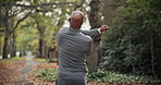 Senior, fitness and black man with stretching in nature for workout preparation or outdoor exercise. Elderly, back view or male person with arm warm up for training, health or wellness in park