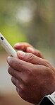 Message, scroll and hands with phone, outdoor and communication with contact on social media or web. Texting, space and person with mobile app, bokeh and networking with internet connection and chat