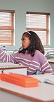 Bored, thinking and child in classroom at school for development, growth or decision on learning. Education, serious and girl student with problem solving, fatigue or academic burnout on campus.