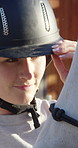 Helmet, outdoor and woman with harness on horse for riding, adventure and equestrian hobby. Countryside, jockey and person with saddle on animal on ranch for trail ride, lesson and training in nature