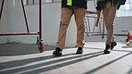 Construction, legs or people on site with inspection, safety check or review of building project. Walk, team or engineer with quality control, progress track or evaluation in industrial compliance.