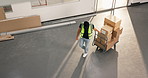 Man, boxes and trolley in warehouse for logistics, fulfillment and supply chain for stock delivery. Above person, walking or cardboard at depot with shipping, dispatch and cargo for distribution