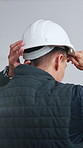 Back, man and architect at construction site with helmet, inspection and workplace injury prevention. Architecture inspector, person and PPE in building for safety compliance, protocol and rules. 