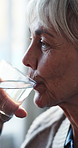 Thinking, old woman and relax at house with water, hydration and vision for health benefits. Senior person, drinking and aqua beverage in lounge with reflection, detox liquid and improve digestion