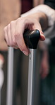 Person, hands and waiting with handle suitcase for travel, boarding line or trip departure in row. Closeup, people or grip with luggage for transportation, flight booking or schedule delay in airport