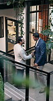 Business, people and handshake in office with greeting, discussion and real estate agent partnership. Above, happy men and shaking hands on stairs with realtor conversation, update and collaboration.