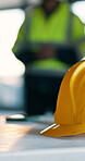Building, helmet and meeting with construction worker in office for architecture or development. Civil engineering, hard hat and planning with builder on site for maintenance or project management