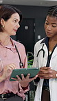 Doctor, tablet and team in hospital for medical information, records and telehealth app for advice. Women, technology and mentor talking of internet for healthcare schedule, results and research