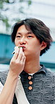 Eating, walking and man with onigiri for travel, holiday or weekend trip with lunch, snack or meal. Local food, outdoor and Japanese person with rice ball for health on adventure, break or vacation.