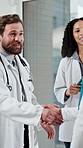 Handshake, meeting and team of doctors in hospital for healthcare schedule, partnership or contract. Happy, professional and group of medical employees shaking hands for collaboration in clinic.