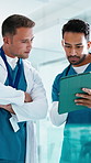 Nurses, people and conversation with tablet in hospital for research, digital app or test results. Men, smile and medical service in clinic with tech, decision and healthcare schedule discussion