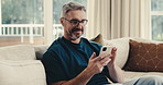 Happy, man and typing in home with phone, social media and online entertainment on peaceful weekend. Mature person, smile and relax in living room with tech, mobile app and internet connectivity.