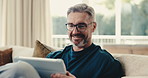 Happy, man and scroll in home with tablet, reading ebook and internet connectivity on calm weekend. Mature person, smile and relax on lounge with tech, research and thinking for online story choice.
