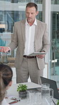 Businessman, meeting and presentation with tablet in office for project management or proposal. Man, employee or speaker talking to team with technology in boardroom for briefing or brainstorming