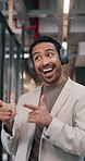 Happy, man and dance in office with greeting, headphones and listen to music for positive attitude. Excited, person and walk in business with audio tech, groove playlist and pointing at colleagues.