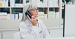 Mature, doctor and phone call in pharmacy for medical assistance, advice or healthcare service. Female person, pharmacist or talking with telephone or computer for Telehealth, virtual support or help