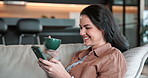 Coffee, woman and smile with phone in home for dating app, reading profile or browse site. Drink, happy person or scroll with mobile in house for online connection, social media post or status update