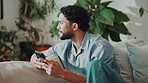 Phone, relax and thinking with happy man on sofa in home living room for social media browsing. App, connectivity and networking with thoughtful mobile user in apartment for text message decision