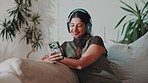 Relax, phone and woman with headphones in home for playlist, podcast and streaming song on weekend. Mobile, music and happy person in lounge, listening to audio and radio for hip hop on internet