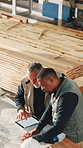 Tablet, mean and writing on blueprint for carpentry project, dimension revision or drawing update. Tech screen, above and team in workshop for joinery specs, layout change and order correction on CAD