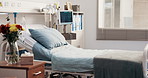 Empty, hospital and bed in ward for medical, admission and inpatient care for surgery treatment. Interior, icu room and flowers in facility with furniture, vital signs machine and healthcare services