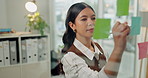 Woman, business and writing with sticky note for schedule planning, ideas or agenda in office. Female person, planner  or thinking with reminder on glass window for brainstorming tasks in workplace