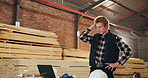 Carpenter, man and stress in workshop with laptop, wrong furniture design and manufacturing error. Flare, person and worry in factory with computer, woodwork production mistake and reading bad news.