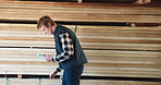 Man, carpenter and checking stock with tablet for wood production or distribution in warehouse. Male person, carpentry or inventory with technology or app for supply chain, timber or lumber logistics