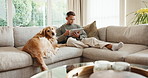 Tablet, reading and man with dog on sofa in home for research on pet adoption, foster care or wellness. Relax, digital technology and person on blog app for animal health in house with puppy.