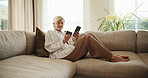Mature, phone and happy woman with credit card on sofa for payment success or discount in home. Female person, shopper and debit with fist pump on smartphone for online shopping, deal or cashback app