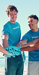 Volunteer, team or stack hands with people at beach or community service or cleaning environment. Celebration, smile or applause with collaboration for NGO mission, recycling goal or reduce pollution