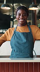 Face, waitress or happy woman at cafe for hospitality, welcome or customer service industry. Barista, smile or black person with confidence, positive attitude or portrait at counter in small business