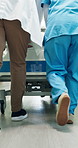 Legs, people and walk in hospital with stretcher, admission and emergency for urgent surgery. Feet, doctor or nurse hurry in lobby with gurney, critical care and operation room for healthcare service