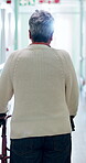 Walker, old person and back view in hallway for mobility, rehabilitation and healing from injury. Balance, aid and woman in hospital for hip replacement, senior care or recovery with movement