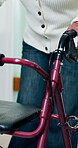 Walker, person and walk in hallway for mobility, exercise or rehabilitation for injury healing. Balance, aid and legs with woman in hospital for hip replacement, senior care or recovery with movement