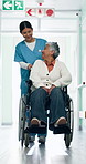 Laugh, nurse and senior woman in wheelchair in hospital for support, checkup or medical assistance. Walking, caregiver and elderly person with disability in clinic for consultation, help or discharge